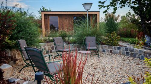 a group of chairs sitting in a garden at Casa Slarku - Luxury Container Houses in Miskolc