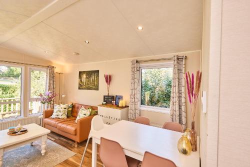 a living room with a table and a couch at Chalet huisje Bella op de Veluwe max 2 volwassene in Beekbergen