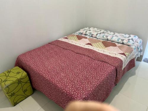 a bed with a colorful quilt on top of it at Residencial Jasmim quarto Standard 01 in Palmas