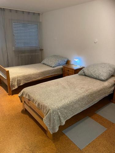 a room with two beds and a light on a table at Park und Therme in Bad Wildbad