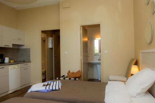 a living room with a couch and a kitchen at Résidence de Tourisme Vacances Bleues Villa Regina in Arcachon