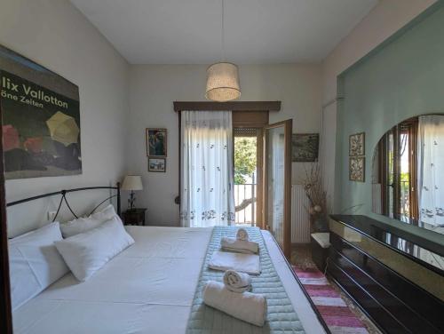 a bedroom with a large white bed with towels on it at Μπαλκόνι του Αιγαίου/ Aegean balcony in Tsagarada