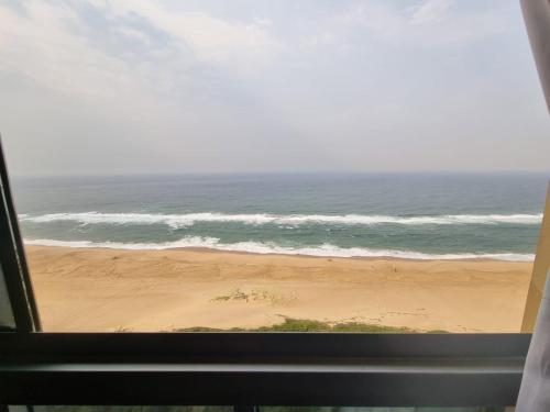 a view of the ocean from a window of a beach at 2102 Amanzi in Amanzimtoti