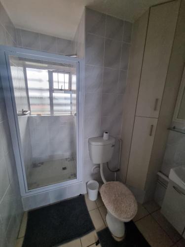 a bathroom with a toilet and a sink and a window at 2102 Amanzi in Amanzimtoti