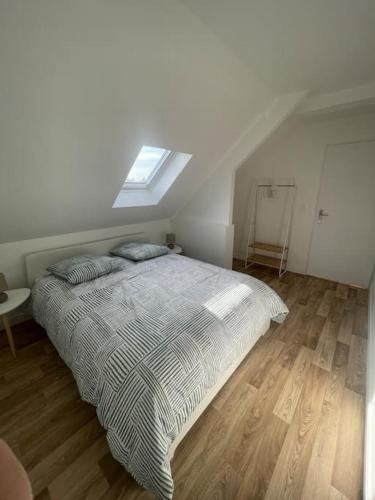 a bedroom with a bed and a skylight at L'Impasse Maison avec Jardin in Isbergues