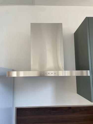 a silver shelf in a kitchen with a mirror at L'Impasse Maison avec Jardin in Isbergues