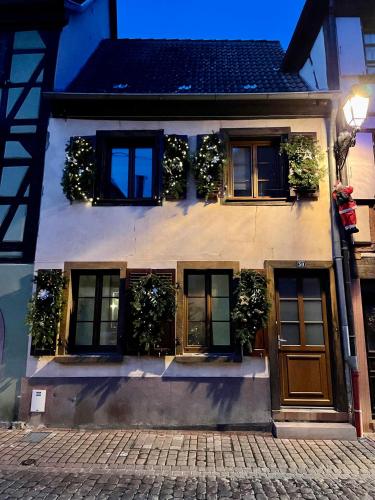 a house with plants on the windows and a door at Le Trente à Turckheim in Turckheim