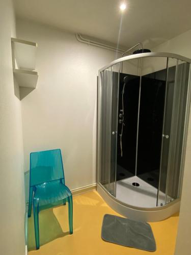 une chaise bleue et un miroir dans la chambre dans l'établissement les moulins - T2 - appartement 4, à Cherbourg en Cotentin