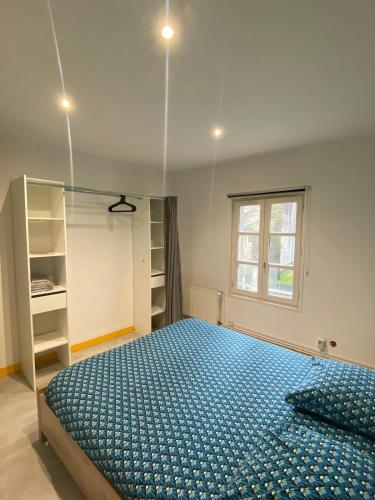 une chambre avec un lit dans une pièce avec une fenêtre dans l'établissement les moulins - T2 - appartement 4, à Cherbourg en Cotentin