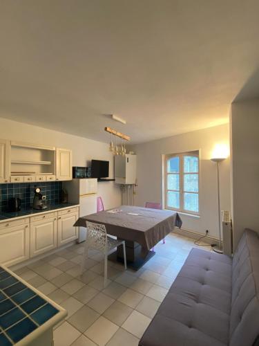 un salon avec une table et une cuisine dans l'établissement les moulins - T2 - appartement 4, à Cherbourg en Cotentin