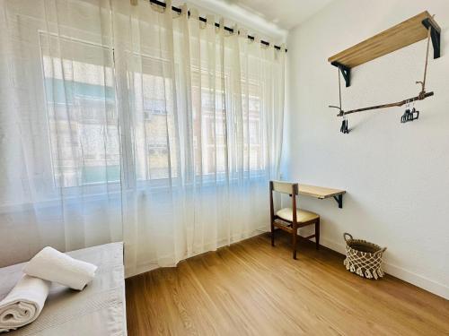 una camera da letto con una scrivania, un letto e una finestra di Autentic Boutique Moncloa a Madrid