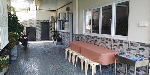 a room with a bench and a table on a building at FNT Transient House near Hundred Islands in Alaminos
