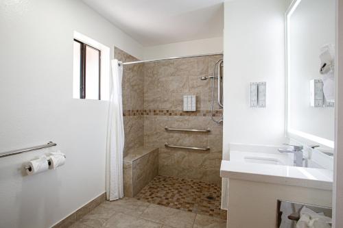 a white bathroom with a shower and a sink at GreenTree Inn Sedona in Sedona