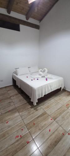 a bed in a room with red rose petals on the floor at Pousada Prumirim Surf Suítes in Ubatuba