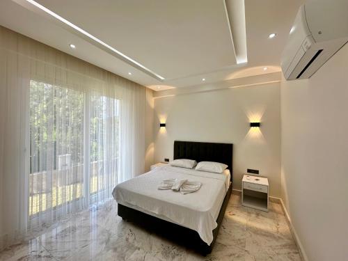 a bedroom with a bed and a large window at Kemer Vıllas De LLuvia in Kemer