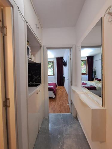 a hallway leading to a bedroom with a mirror at Garsoniera Flori - Sinaia in Sinaia