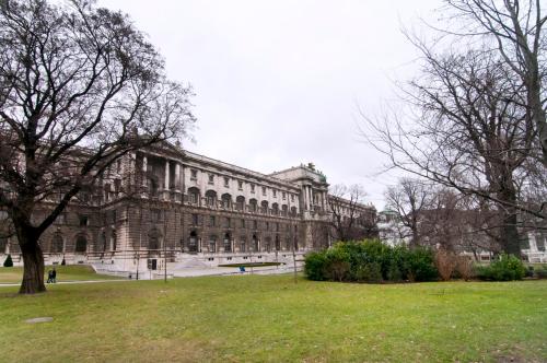 ein großes Steingebäude mit einem Park davor in der Unterkunft HeyMi Apartments Oper in Wien