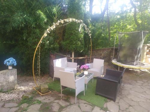 a patio with white chairs and an arch and a table at Aitzkorri Zegama in Arrietas