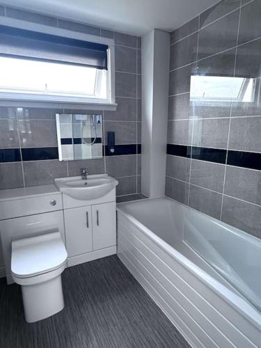 a bathroom with a toilet and a tub and a sink at Luxury Home in Luton - Near L&D Hospital - FREE Netflix & Wifi- FREE Parking in Lewsey