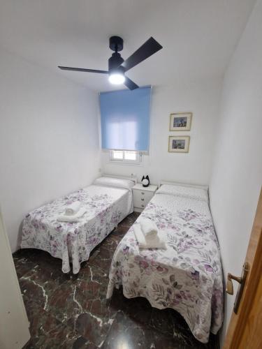 een slaapkamer met twee bedden en een plafondventilator bij Marfil 6 in Salobreña