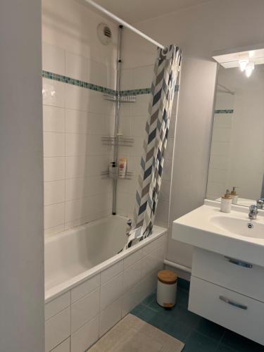 une salle de bain avec une baignoire et un lavabo dans l'établissement La Fleur de Montmagny, à Montmagny