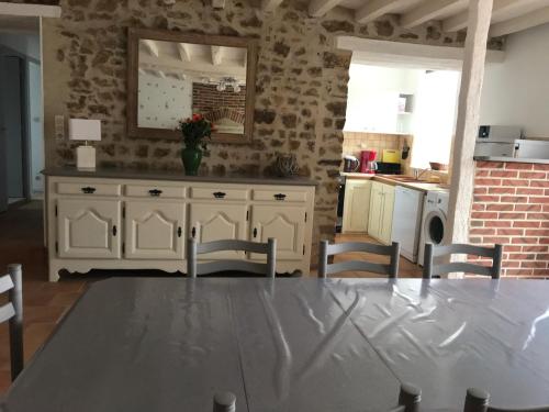 une cuisine avec une table, des chaises et un comptoir dans l'établissement petit gite l'ecotay, à Tennie