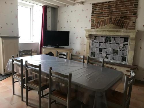 une salle à manger avec une table et des chaises et une cheminée dans l'établissement petit gite l'ecotay, à Tennie