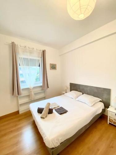 un grand lit blanc dans une chambre avec une fenêtre dans l'établissement Résidence Les Oliviers de Juin, à Vence