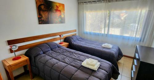 Un dormitorio con dos camas y un sofá. en Belgrano 555, en San Martín de los Andes