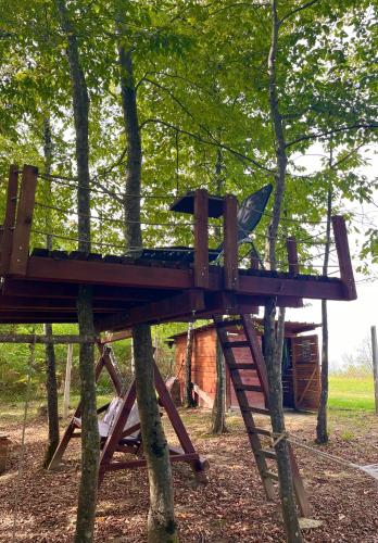 a tree house with a playground in the trees at Vikendica Novska planina in Rudice