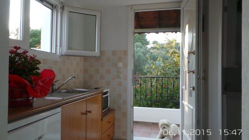 a kitchen with a sink and a view of a balcony at Skiathos Studios Panorama in Skiathos
