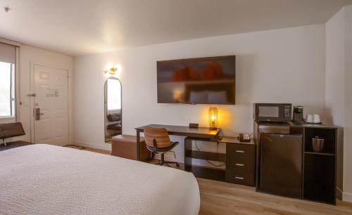 a bedroom with a bed and a desk with a microwave at GreenTree Inn Sedona in Sedona