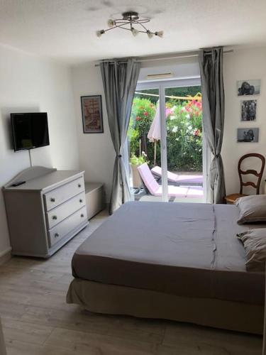 une chambre avec un lit, une télévision et une fenêtre dans l'établissement Villa avec piscine SAINT-RAPHAEL, à Valescure