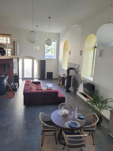 un salon avec un canapé et une table dans l'établissement L'instant des Plaisirs, à Héming