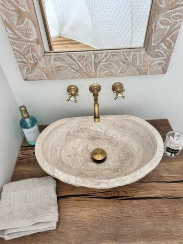 a sink in a bathroom with a mirror at The Cokoon at the Retreat in Fredericksburg