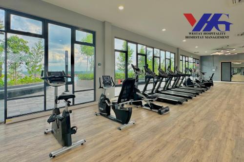 a gym with a row of treadmills and ellipticals at Alanis Suite With Netflix @ KLIA Sepang in Sepang