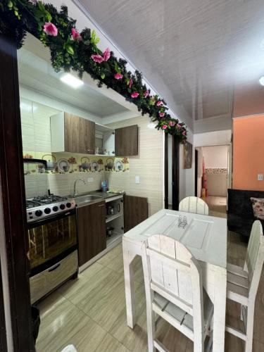 a kitchen with a table with flowers on the ceiling at Habitación en apartahotel Sarita Salento in Salento