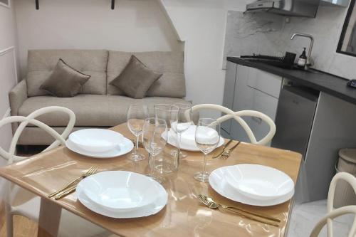 - une table à manger avec des assiettes et des verres à vin dans l'établissement Appartement -Paris Bastille LIGHT, à Paris