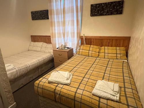 a bedroom with two beds with towels on them at The Stage Door Hotel in Blackpool