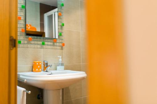 a bathroom with a sink and a mirror at Aticos La Aliseda by Valdesierra in Béjar