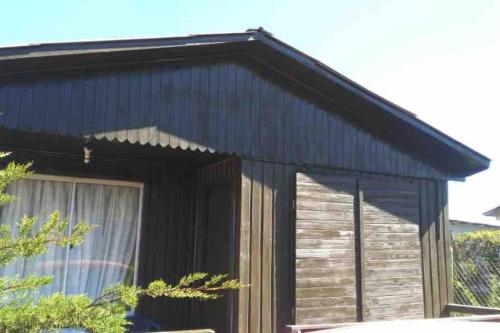 a small black house with a window at Iloca Cabaña Rancura in Iloca