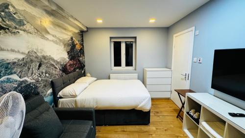 a bedroom with a bed and a flat screen tv at Private Boutique Apartments London in London