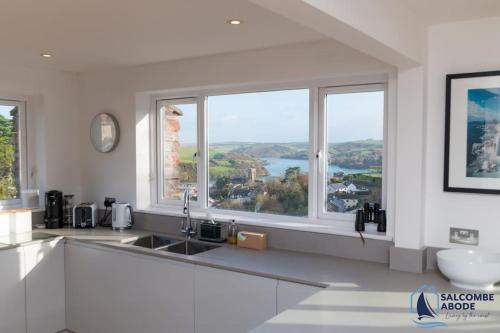 a kitchen with a sink and two windows at Ultimate Coastal Escape - Stylish & Estuary Views in Salcombe