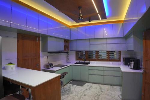 a large kitchen with blue lights on the ceiling at Luxurious 5000 SQFT Mansion with Modern Comforts And Spacious Elegance in Malappuram