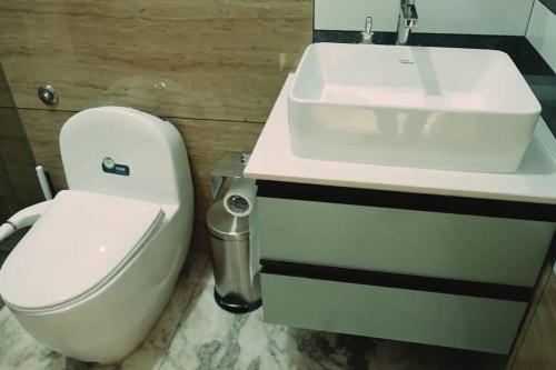 a bathroom with a white toilet and a sink at Luxurious 5000 SQFT Mansion with Modern Comforts And Spacious Elegance in Malappuram