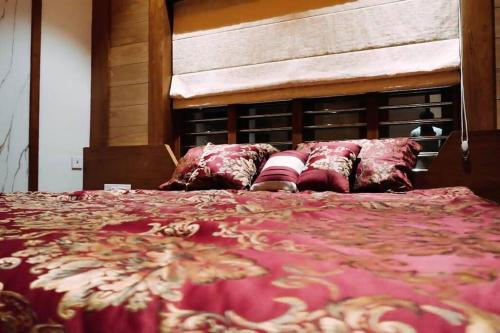 a bed with a red blanket and pillows on it at Luxurious 5000 SQFT Mansion with Modern Comforts And Spacious Elegance in Malappuram