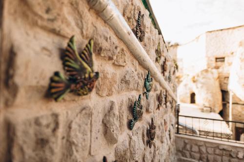 a stone wall with butterflies painted on it at İsadora Cave Cappadocia in Nevsehir