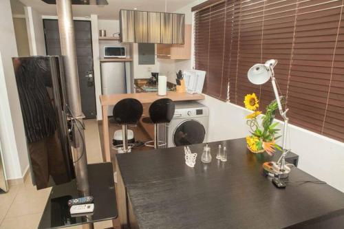 una cocina con una mesa con una lámpara y flores. en Close to Beach King Suite in Town Center, en Playa Blanca