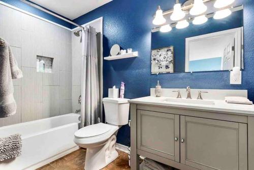 a blue bathroom with a toilet and a sink at Guest Haus w Hot tub, Fire Pit & Vineyard Views in Fredericksburg