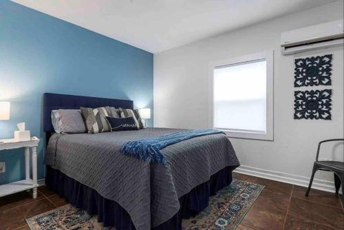 a bedroom with a bed with a blue wall at Guest Haus w Hot tub, Fire Pit & Vineyard Views in Fredericksburg